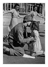 Kiss of Liberation: Sergeant Gene Costanzo kneels to kiss a little girl during spontaneous celebrations in the main square of the town of St. Briac, France, August 14, 1944